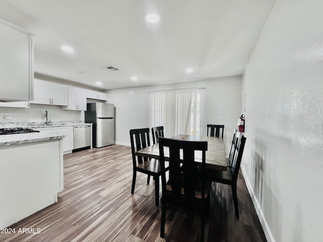 dining room featuring sink and hardwood / wood-style flooring