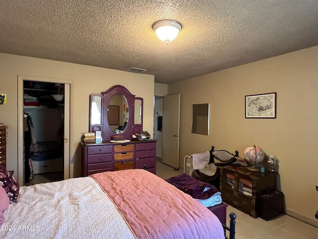 bedroom with a textured ceiling and a closet