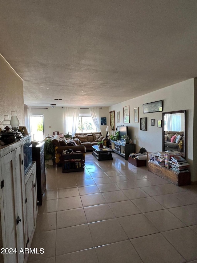 tiled living room featuring a textured ceiling