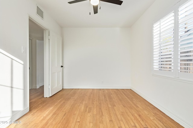 spare room with visible vents, plenty of natural light, light wood-style floors, and baseboards