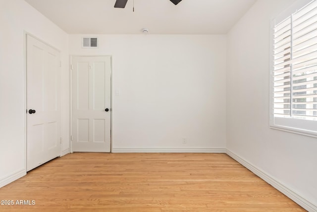 spare room with visible vents, baseboards, light wood-style floors, and a ceiling fan