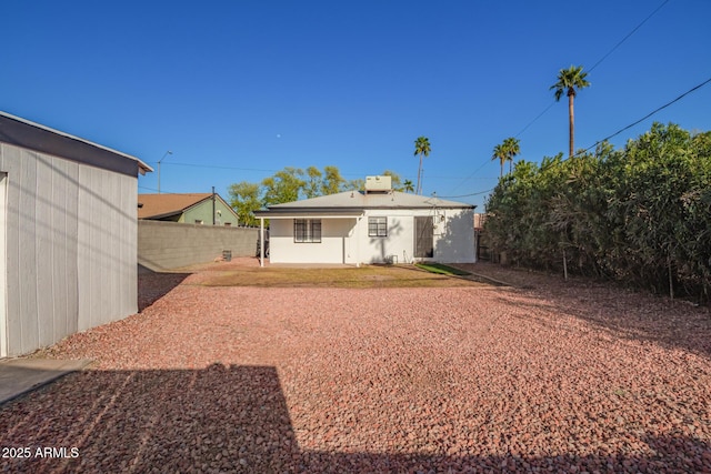 rear view of property featuring a patio area, fence, and stucco siding