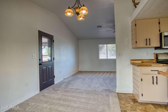 813 N Glenrosa Blvd, Taylor, AZ 85939 - kitchen featuring lofted ceiling, light colored carpet, a chandelier, baseboards, and stainless steel microwave