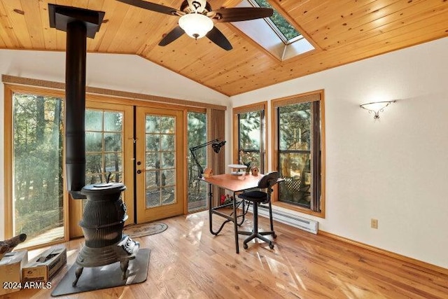 interior space with wooden ceiling, vaulted ceiling with skylight, a healthy amount of sunlight, and light wood-type flooring