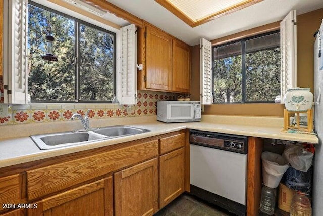 kitchen with tasteful backsplash, sink, and white appliances