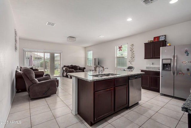 kitchen with open floor plan, light tile patterned floors, stainless steel appliances, a sink, and visible vents