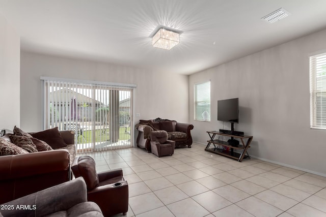 living room with plenty of natural light, baseboards, visible vents, and light tile patterned floors