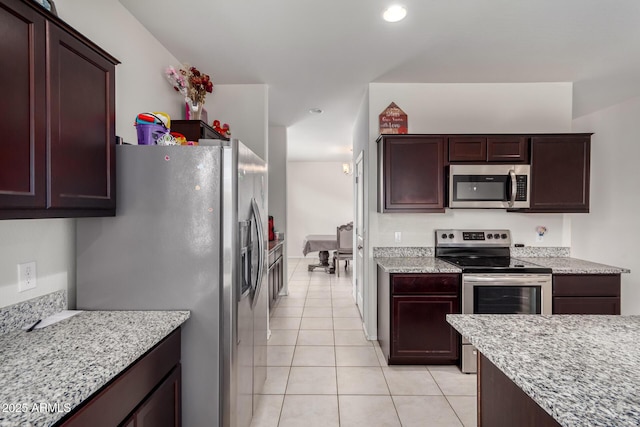 kitchen with light tile patterned flooring, light stone countertops, recessed lighting, dark brown cabinets, and appliances with stainless steel finishes