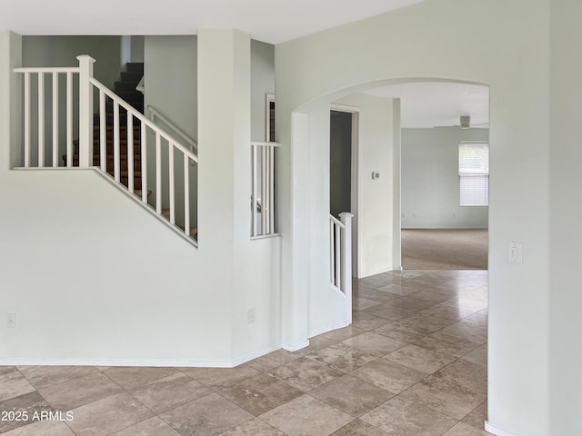 stairs featuring arched walkways and baseboards