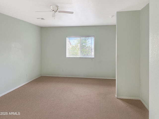 carpeted empty room with visible vents, baseboards, and ceiling fan