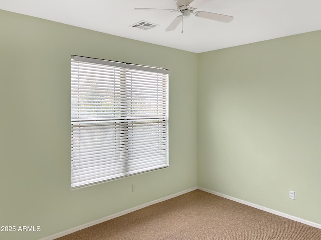 spare room featuring visible vents, baseboards, ceiling fan, and carpet flooring