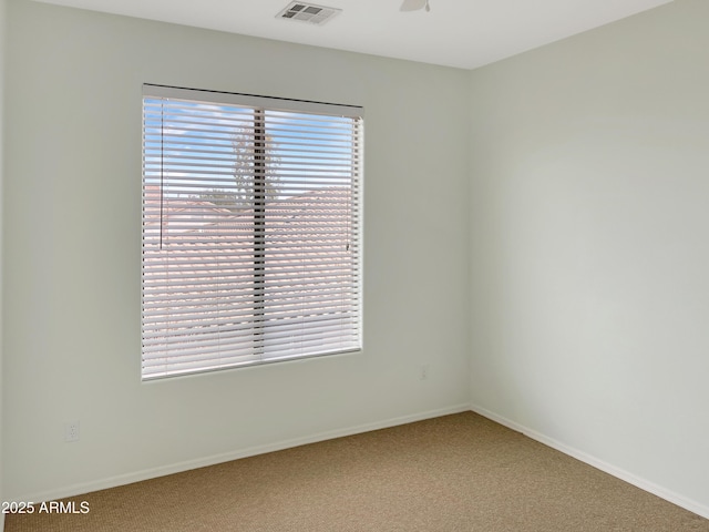 carpeted empty room featuring visible vents, plenty of natural light, and baseboards
