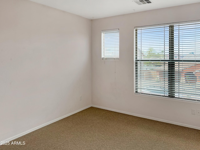 carpeted empty room featuring visible vents and baseboards