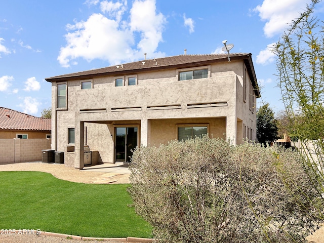 back of house featuring a patio area, a yard, stucco siding, and fence