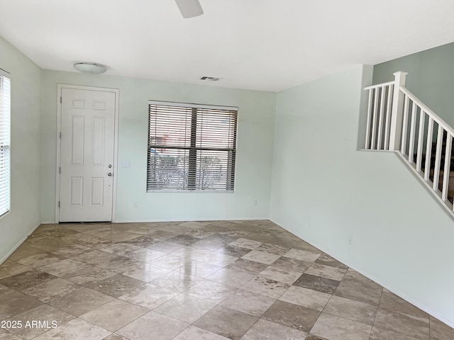 unfurnished room featuring visible vents and ceiling fan