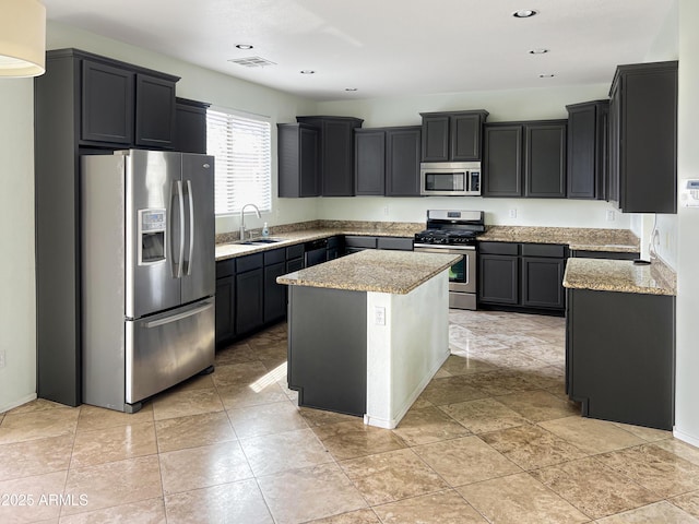 kitchen featuring light stone counters, visible vents, appliances with stainless steel finishes, and a sink