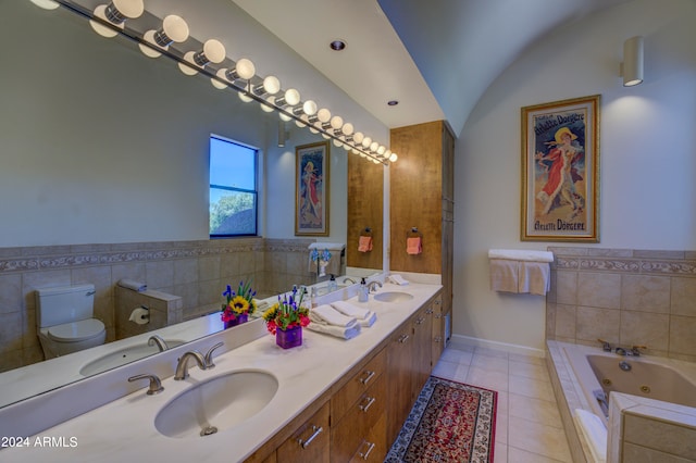 bathroom featuring tile floors, double sink vanity, toilet, tiled bath, and lofted ceiling