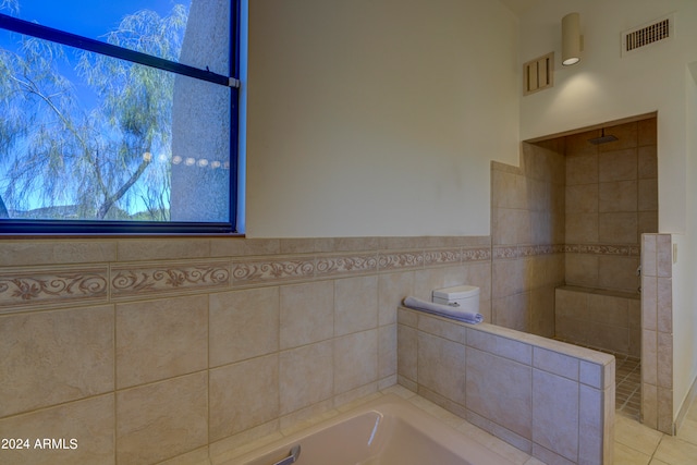 bathroom with tile flooring and tile walls