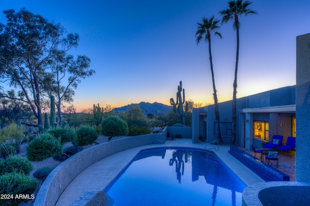 pool at dusk featuring a patio area