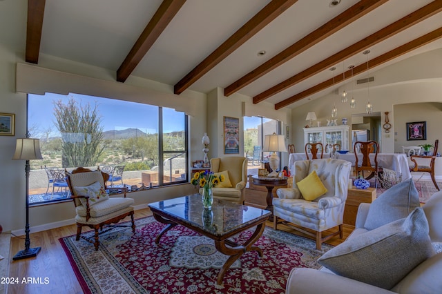 living room featuring vaulted ceiling with beams and light wood-type flooring