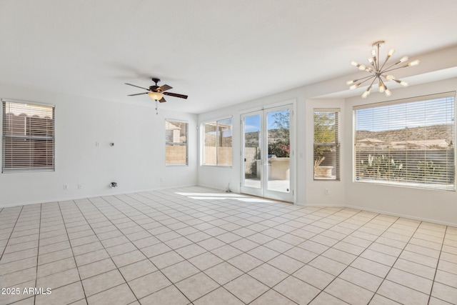 unfurnished room featuring baseboards and ceiling fan with notable chandelier