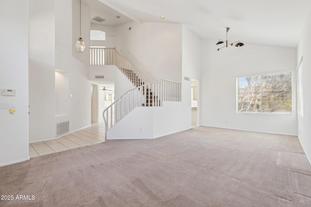 unfurnished living room featuring stairs, light tile patterned flooring, visible vents, and light colored carpet