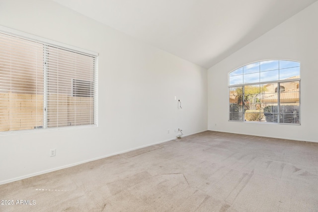 empty room with light colored carpet and vaulted ceiling