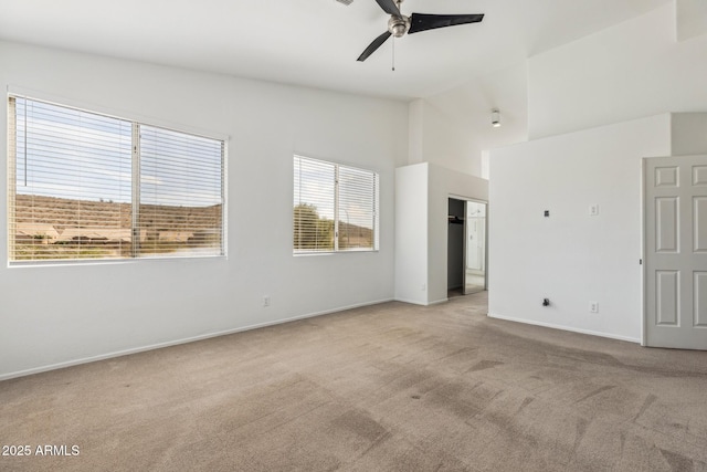 spare room with lofted ceiling, ceiling fan, baseboards, and light colored carpet