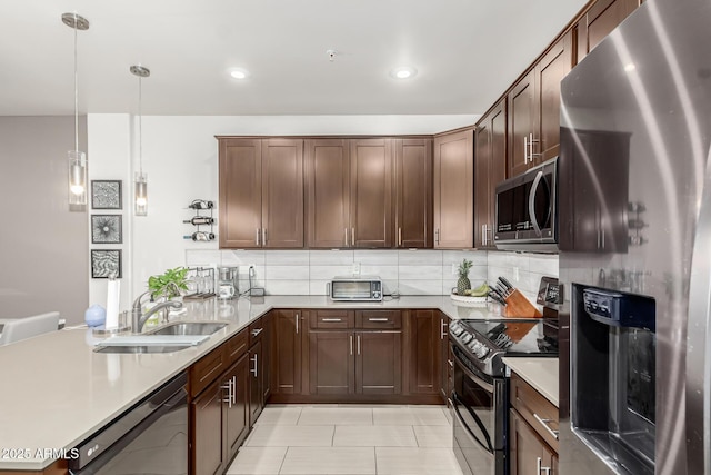 kitchen featuring decorative backsplash, appliances with stainless steel finishes, sink, pendant lighting, and light tile patterned flooring