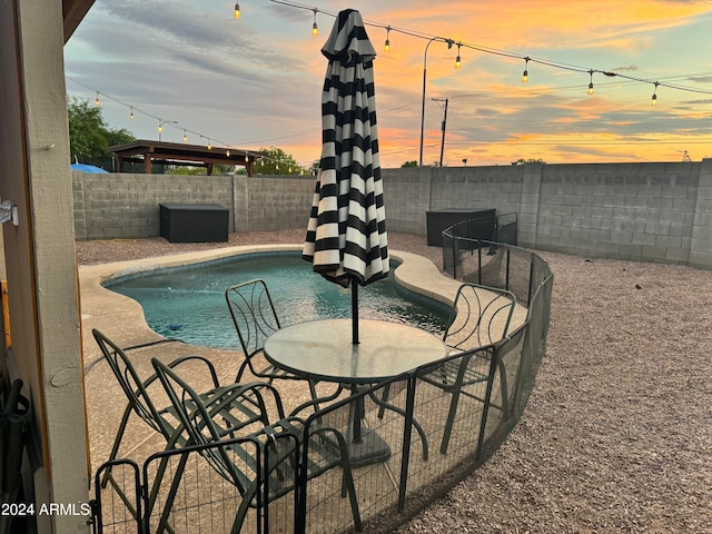 pool at dusk with a patio