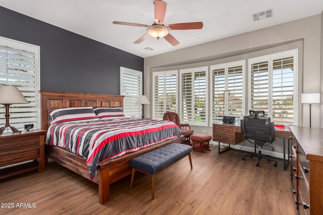 bedroom with multiple windows, wood finished floors, and visible vents