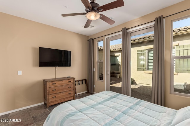 bedroom with baseboards, multiple windows, a ceiling fan, and access to exterior