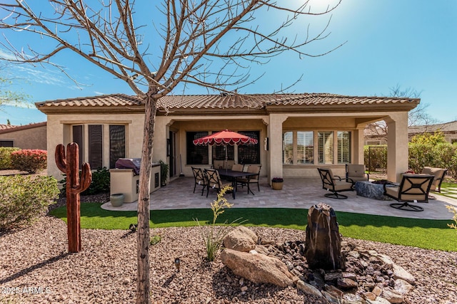 rear view of property with a patio area and stucco siding