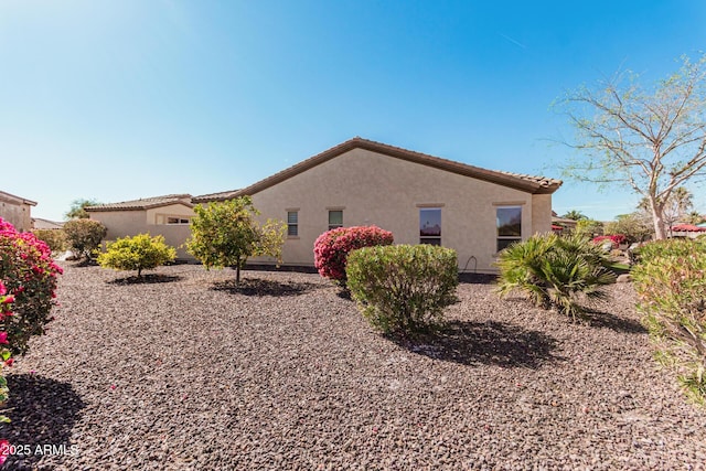 view of property exterior with a tiled roof and stucco siding