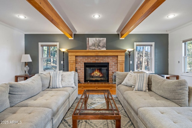 living area with ornamental molding, beamed ceiling, a brick fireplace, and recessed lighting