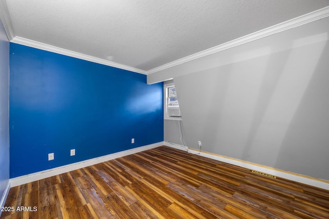 empty room with a textured ceiling, ornamental molding, and wood finished floors