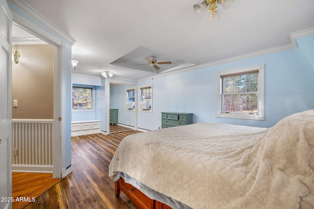 bedroom with dark wood-style floors, ornamental molding, a closet, and a ceiling fan