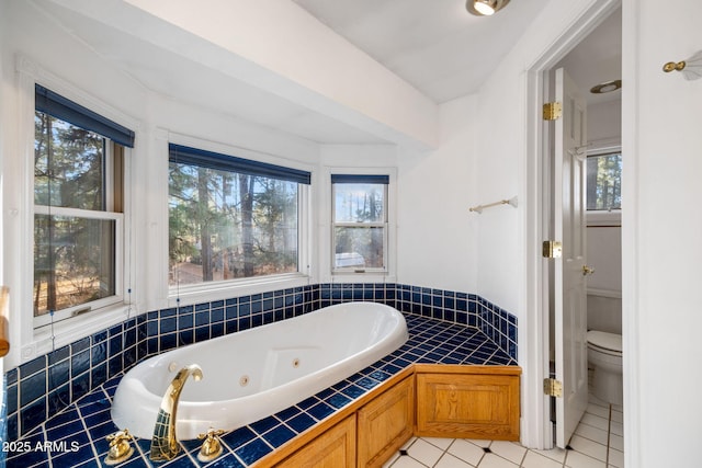 bathroom featuring a jetted tub, tile patterned flooring, and toilet