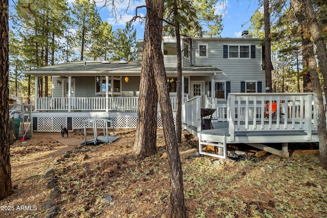 back of property featuring covered porch and a chimney