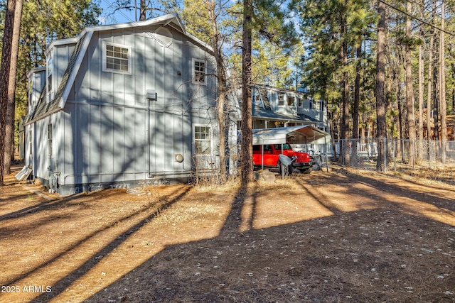 view of property exterior with fence and dirt driveway