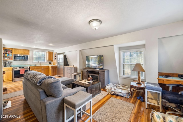 living room with a textured ceiling, wood finished floors, and recessed lighting