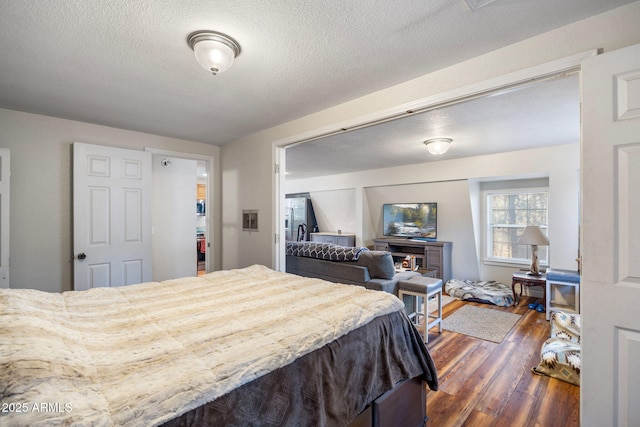 bedroom with dark wood finished floors and a textured ceiling