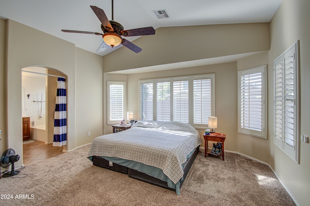 carpeted bedroom with ensuite bathroom, ceiling fan, and lofted ceiling