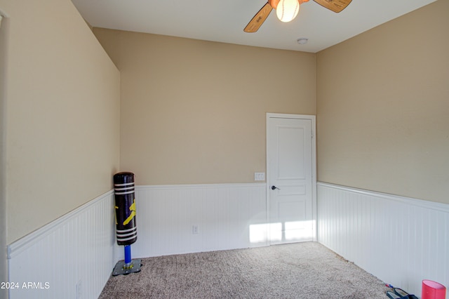 carpeted spare room with ceiling fan