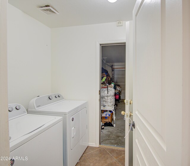 laundry area with washing machine and dryer and light tile patterned floors