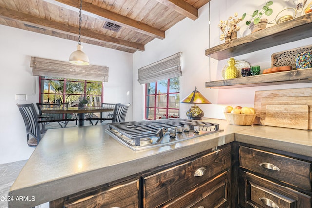 kitchen featuring decorative light fixtures, dark brown cabinets, beamed ceiling, stainless steel gas stovetop, and wood ceiling