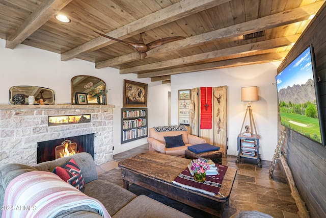 living room with a fireplace, dark tile patterned floors, beamed ceiling, and wood ceiling