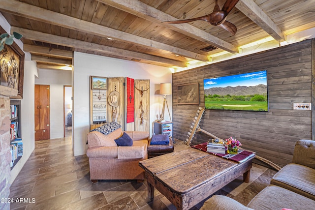 living room featuring tile patterned flooring, beam ceiling, ceiling fan, and wood ceiling