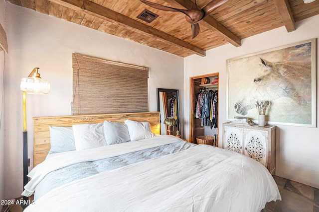 bedroom with beam ceiling, a spacious closet, wood ceiling, a closet, and ceiling fan