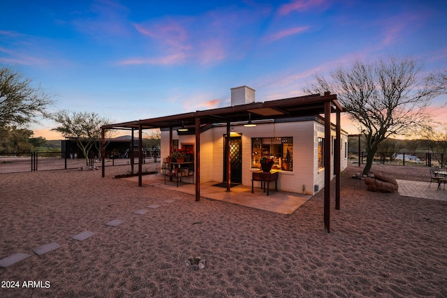 back house at dusk with a patio